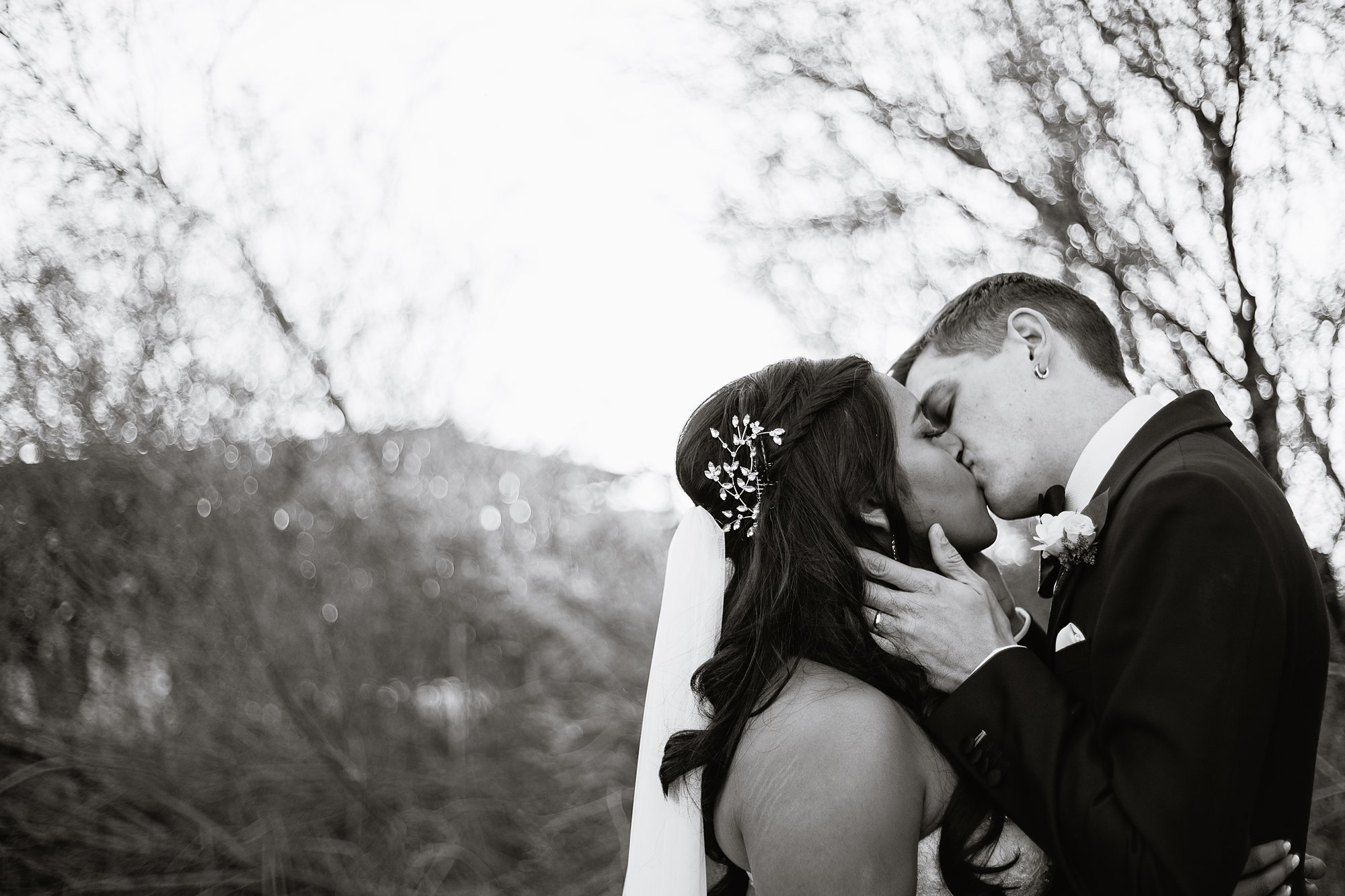 Black and white image of a bride and groom sharing an intimate kiss at the Rio Salado Audubon Center by Phoenix wedding photographers PMA Photography.