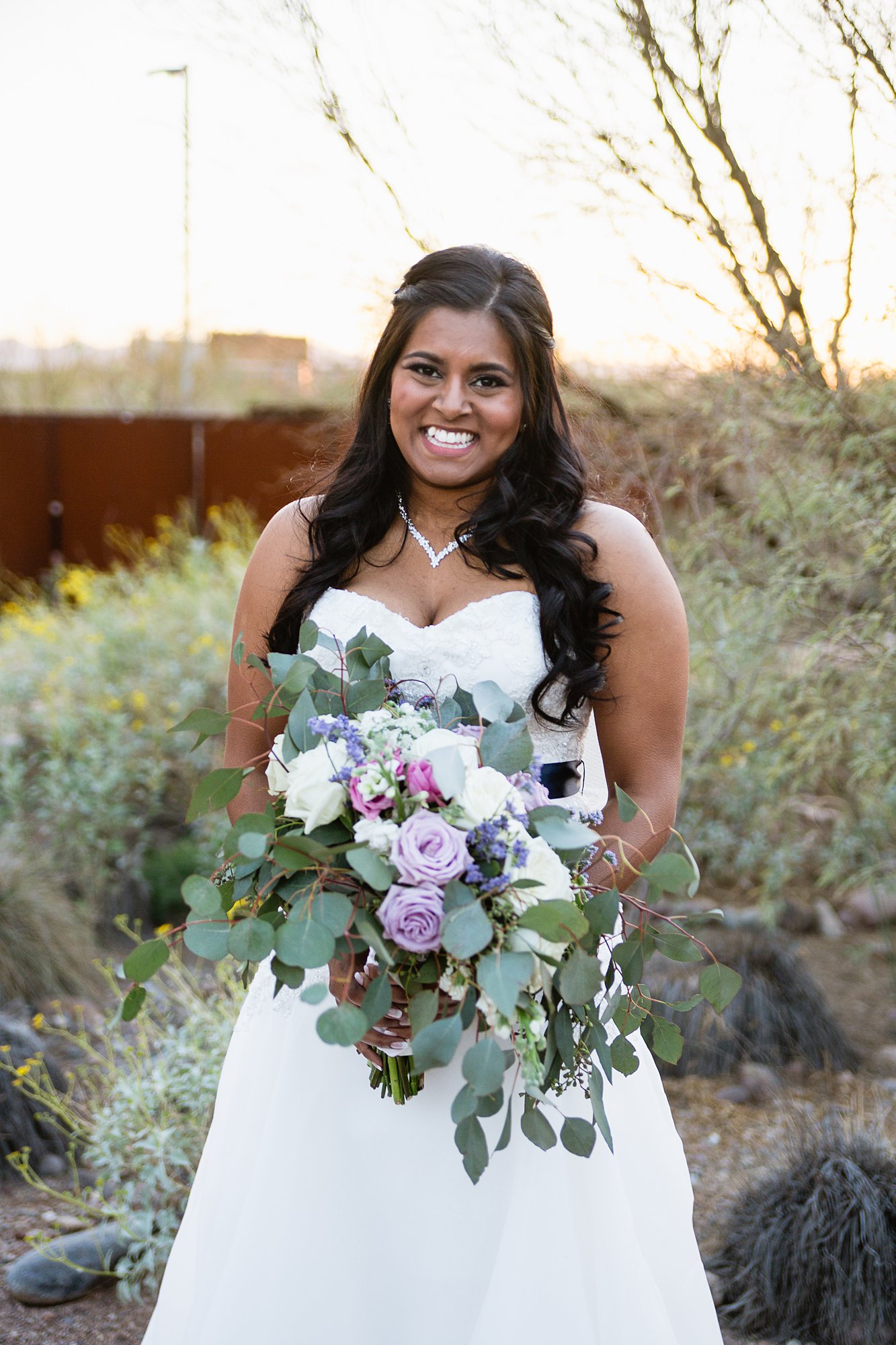 Bride holding lavender and white bouquet at her desert wedding by Phoenix wedding photographer PMA Photography.