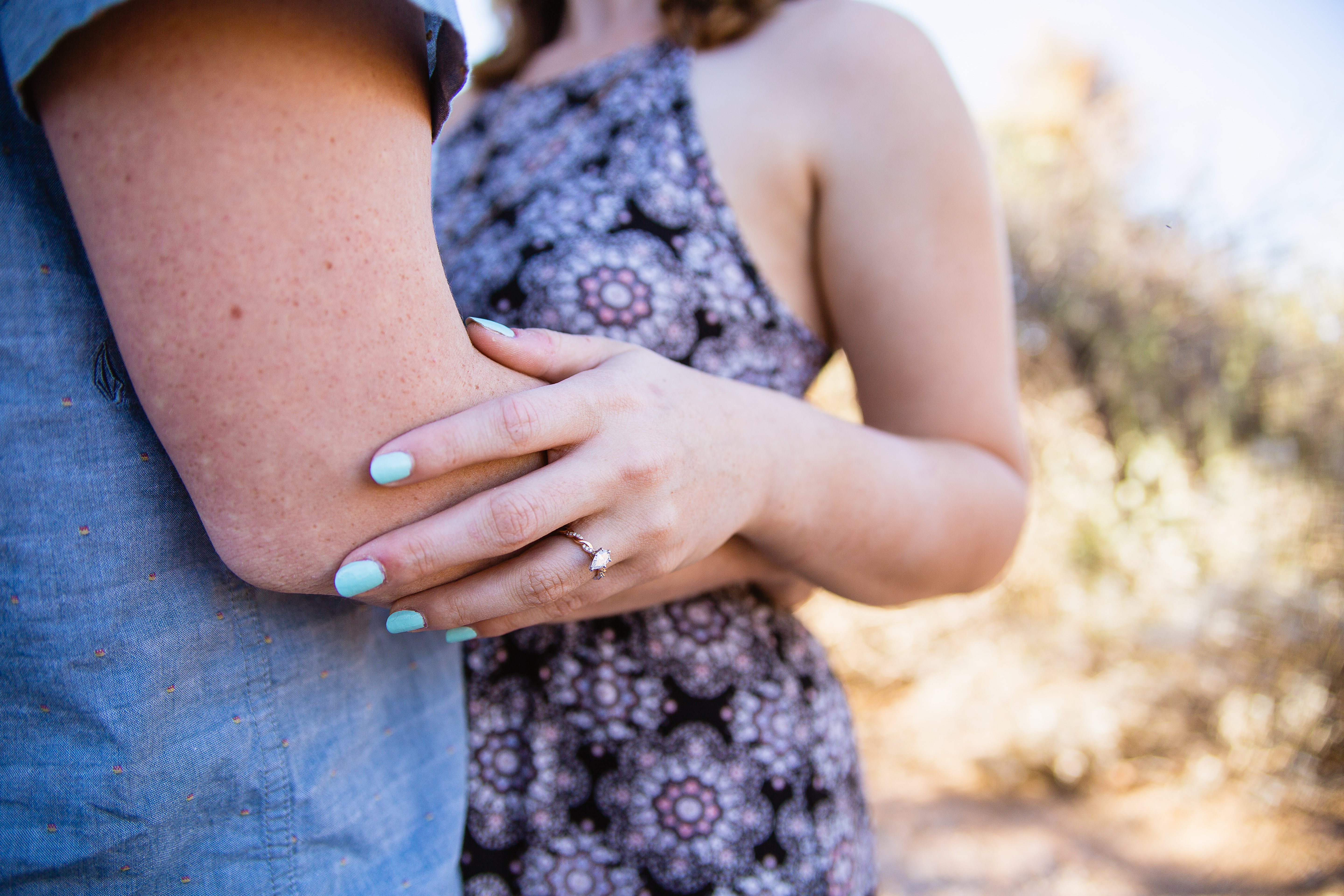 Close up of engagement ring and teal nail polish during engagement session at Lost Dutchman State Park by engagement photographer PMA Photography.