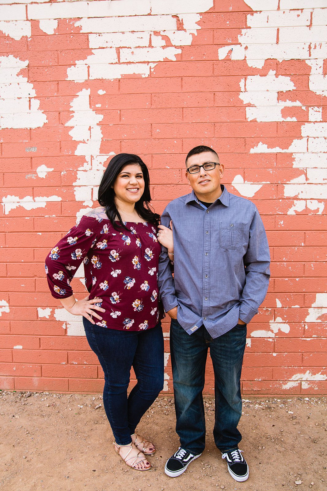 Couple in front of vintage wall with paint chipping off during their Gilbert engagement session by wedding photographer PMA Photography.
