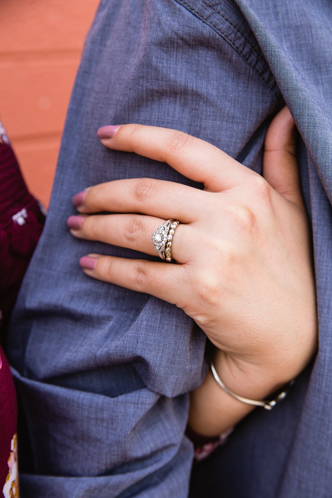 Close up on engagement ring on bride to be's hand.