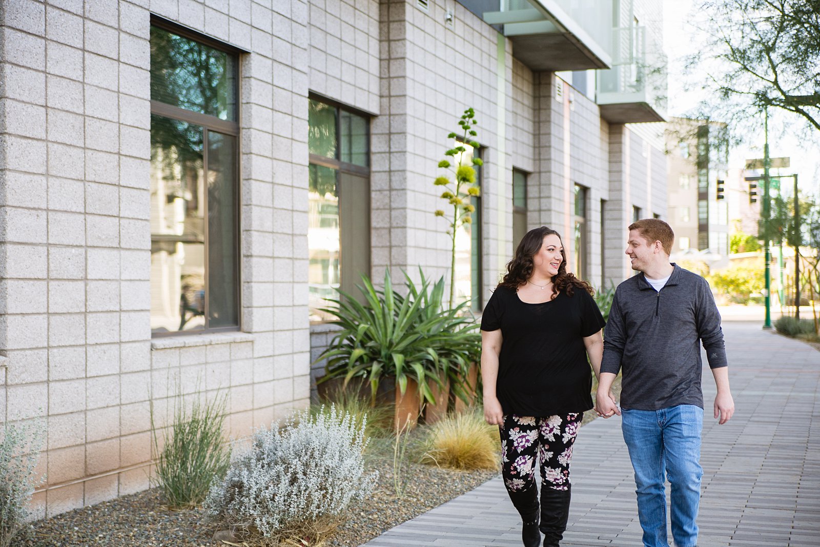 Couple walking in downtown Phoenix for their engagement session by PMA Photography.
