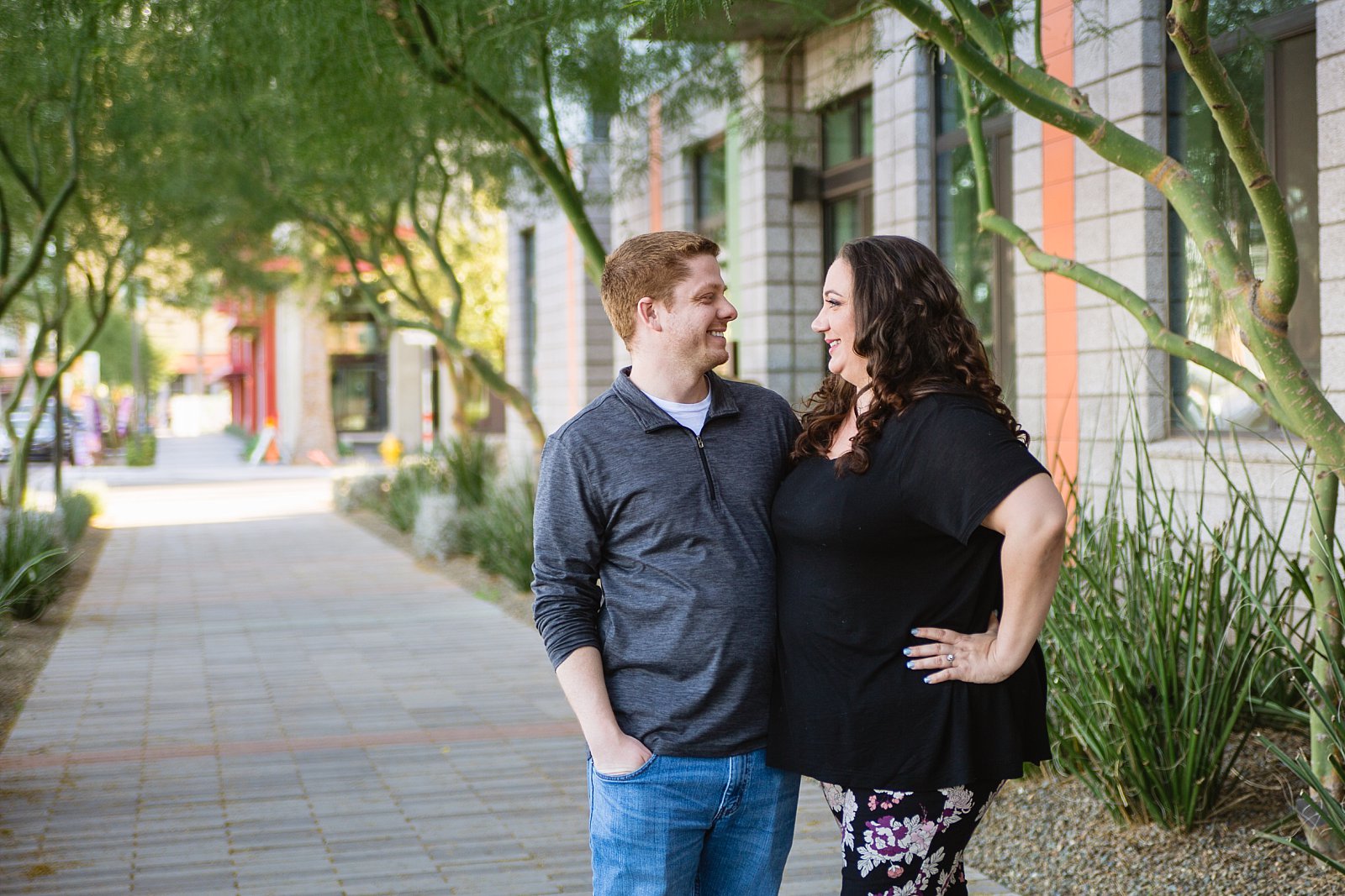 Couple pose on walkway for their downtown Phoenix engagement session by PMA Photography.