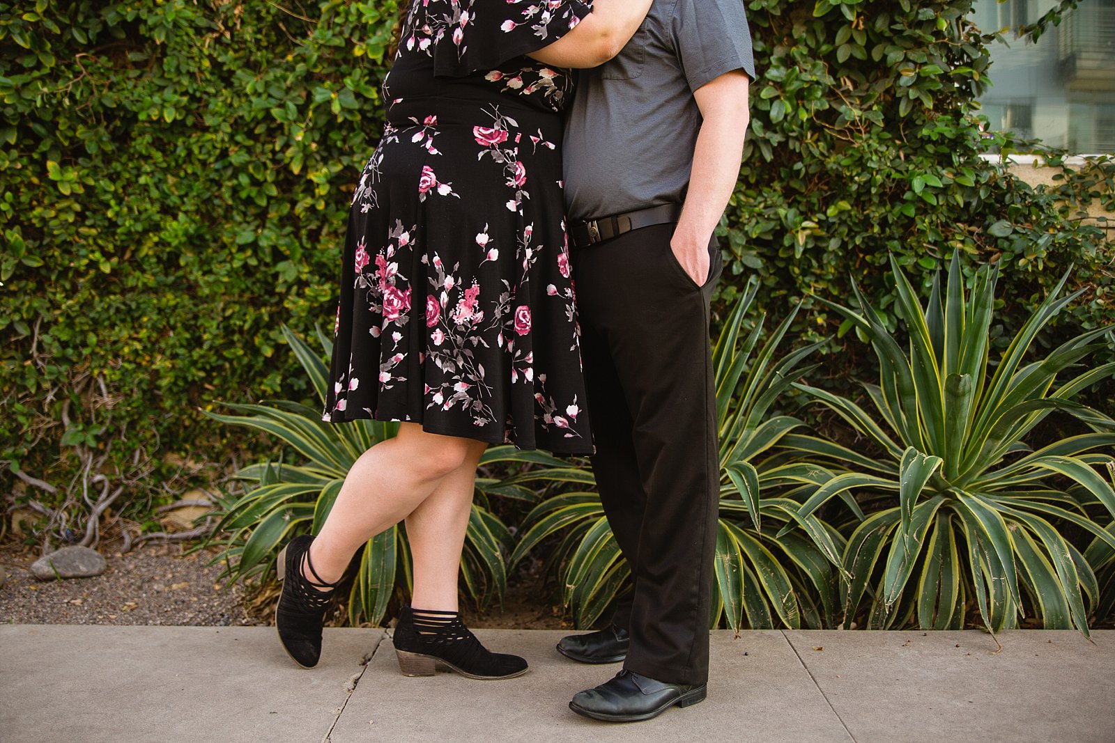 Couple's engagement session outfits in front of living plant wall during their downtown Phoenix engagement session by PMA Photography.