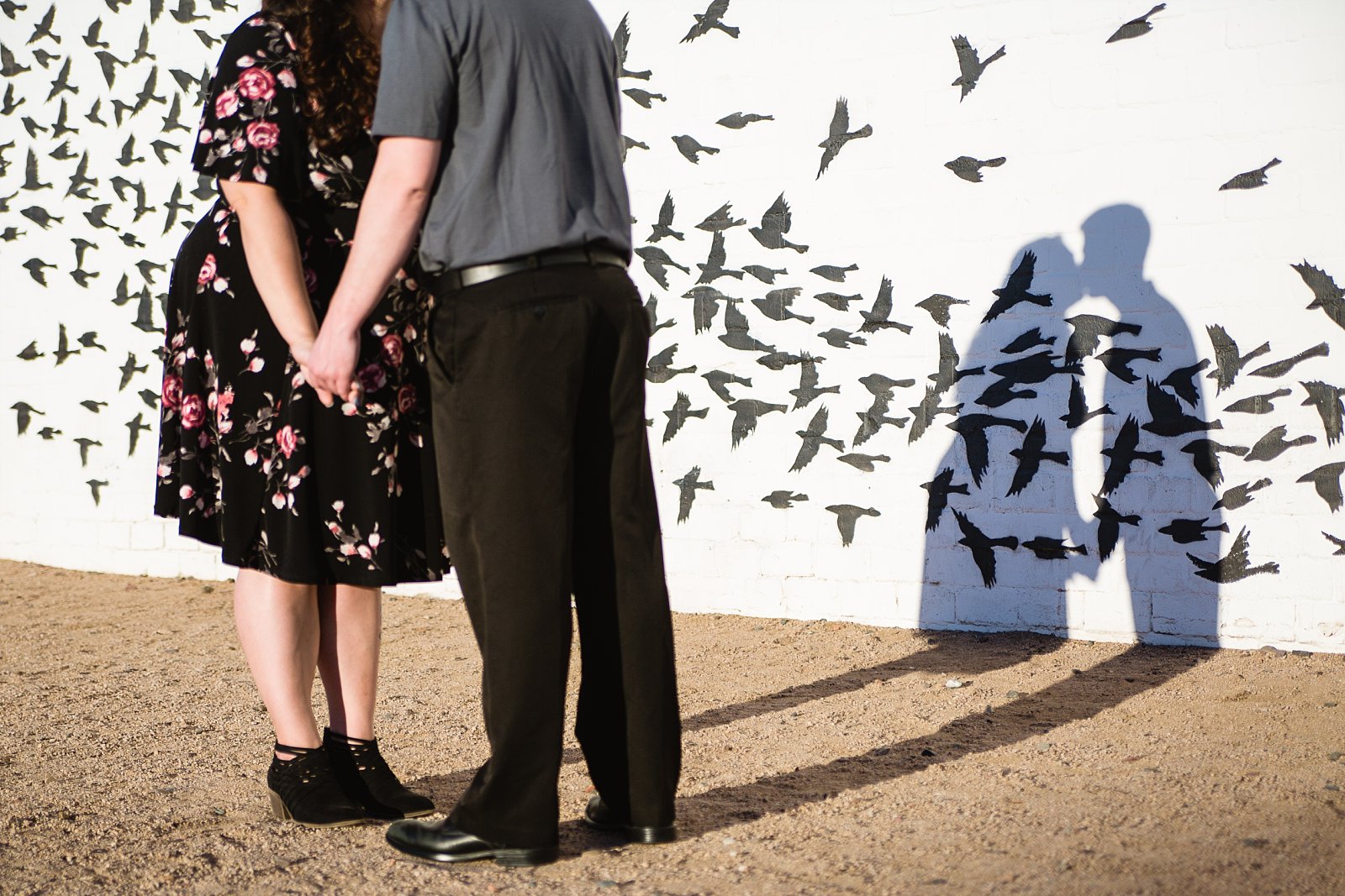 Shadow of couple kissing on an art mural during their Roosevelt Row Art District engagement session by PMA Photography.