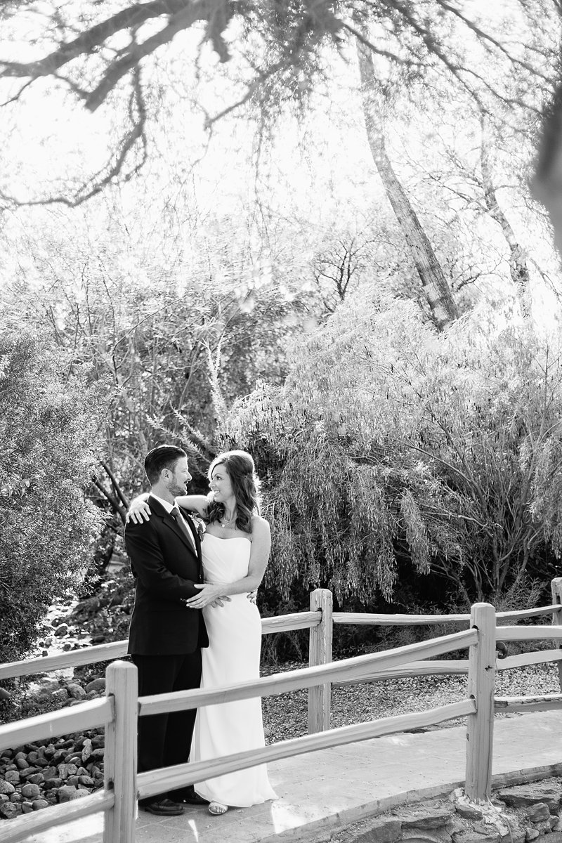 Black and white image of bride and groom looking at each other on a bridge at Hermosa Inn by Phoenix wedding photographer PMA Photography.