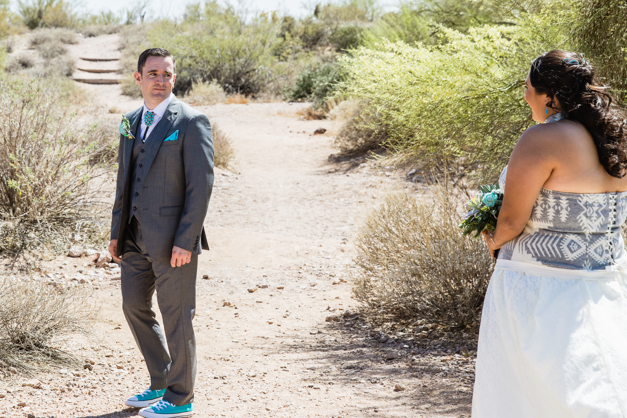Groom seeing his bride for the first time during their first look at Lost Dutchman state park by wedding photographer PMA Photography.
