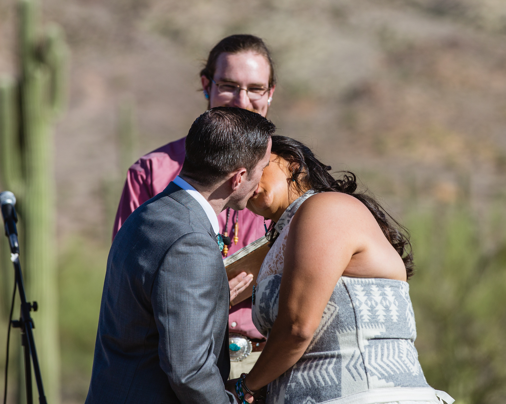 Bride and groom sharing their first kiss as husband and wife by Arizona wedding photographers PMA Photography.