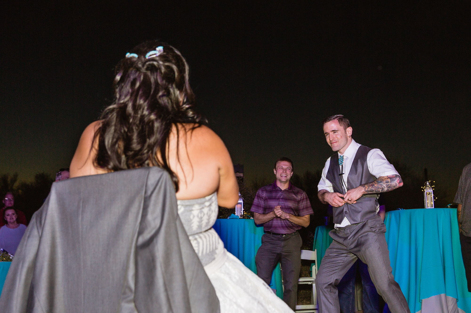 Groom doing a 'sexy' dance before removing the bride's garter by PMA Photography.