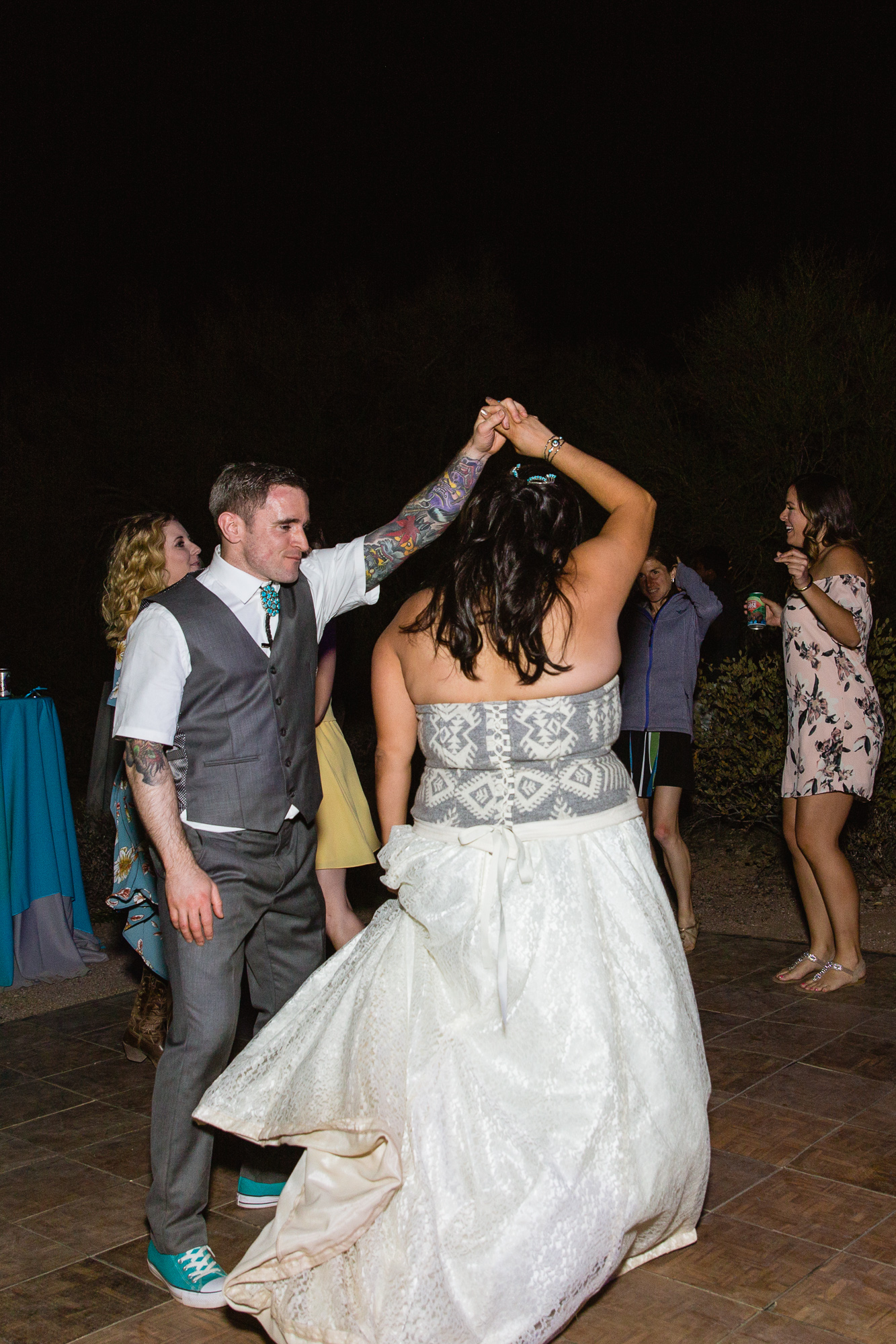 Bride and groom dancing with guests at their wedding reception by Arizona wedding photographer PMA Photography.