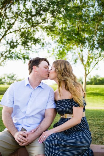 Couple kissing at Anthem Community Park during their engagement session by PMA Photography.