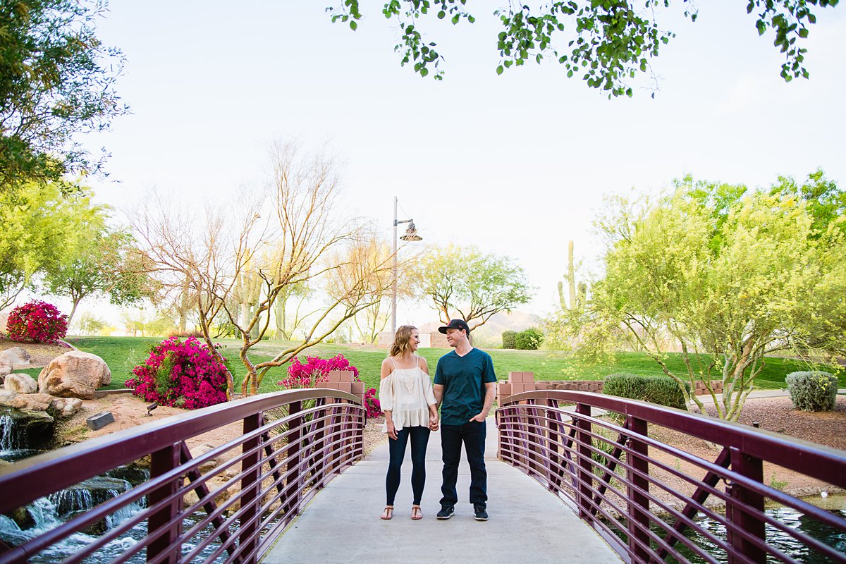 Couple looking in front of each other on a bridge at Anthem Park by PMA Photography.
