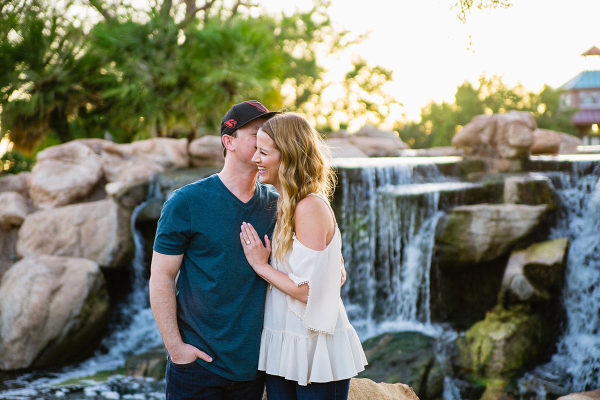 Couple laughing together in front of water fall at their Anthem Community Park engagement session by PMA Photography.
