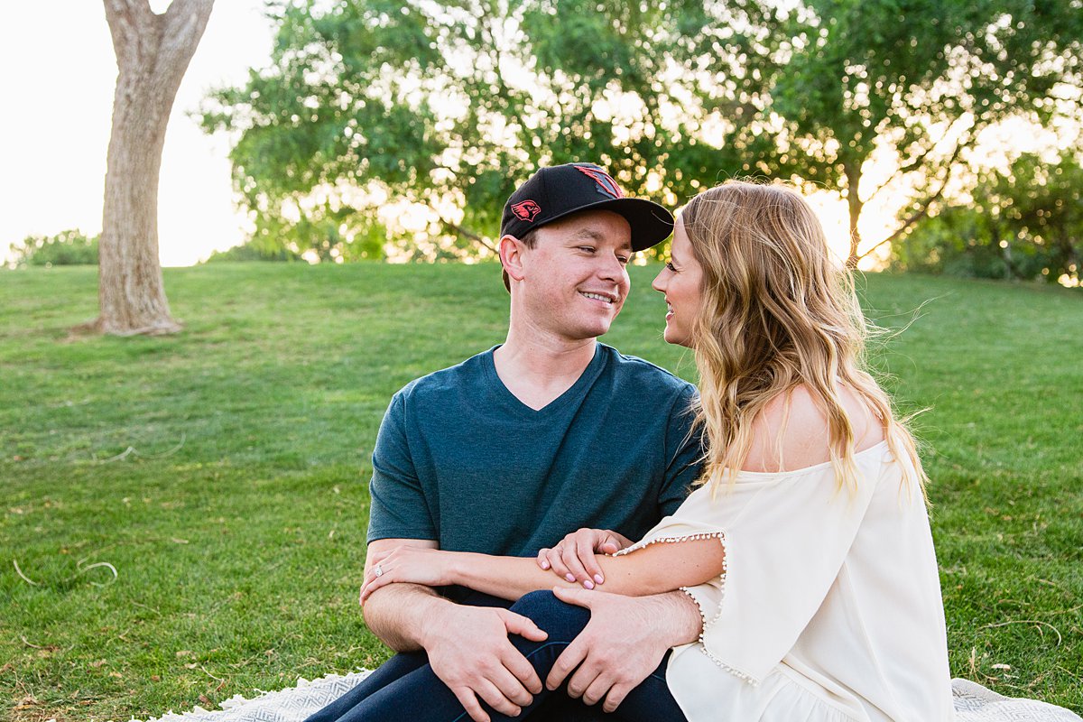 Couple sitting together on a blanket at their Anthem Park engagement session by PMA Photography.