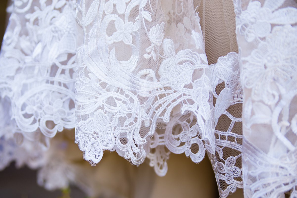 Detail image of the lace on a wedding gown by PMA Photography.