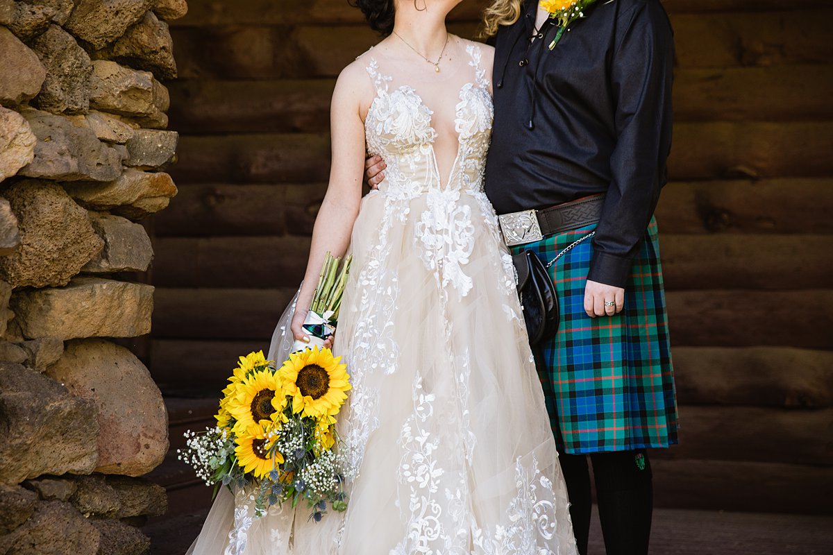 Detail image of the bride's nude and lace wedding dress and the grooms Scottish kilt with sunflower bouquet by wedding photographers PMA PHotography.