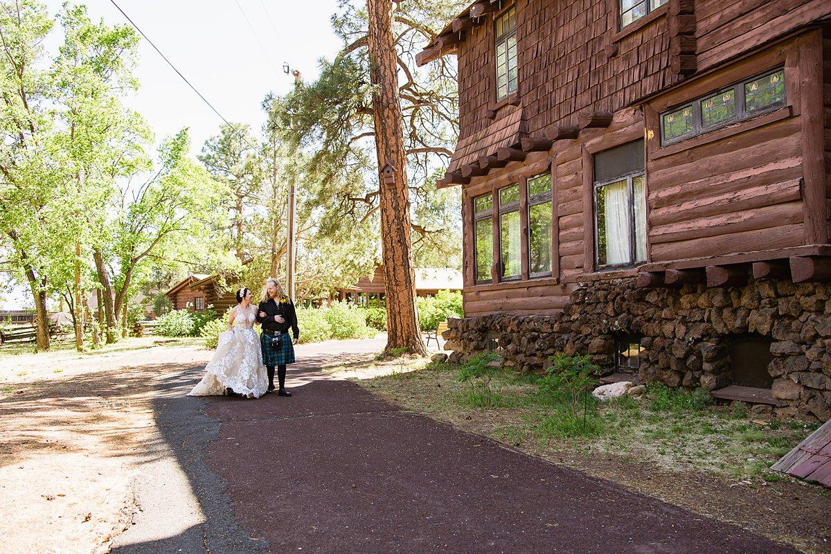 Bride and groom walk together in the woods at the Riordan Mansion at their Scottish and Sunflower inspired wedding by Flagstaff wedding photographers PMA Photography.