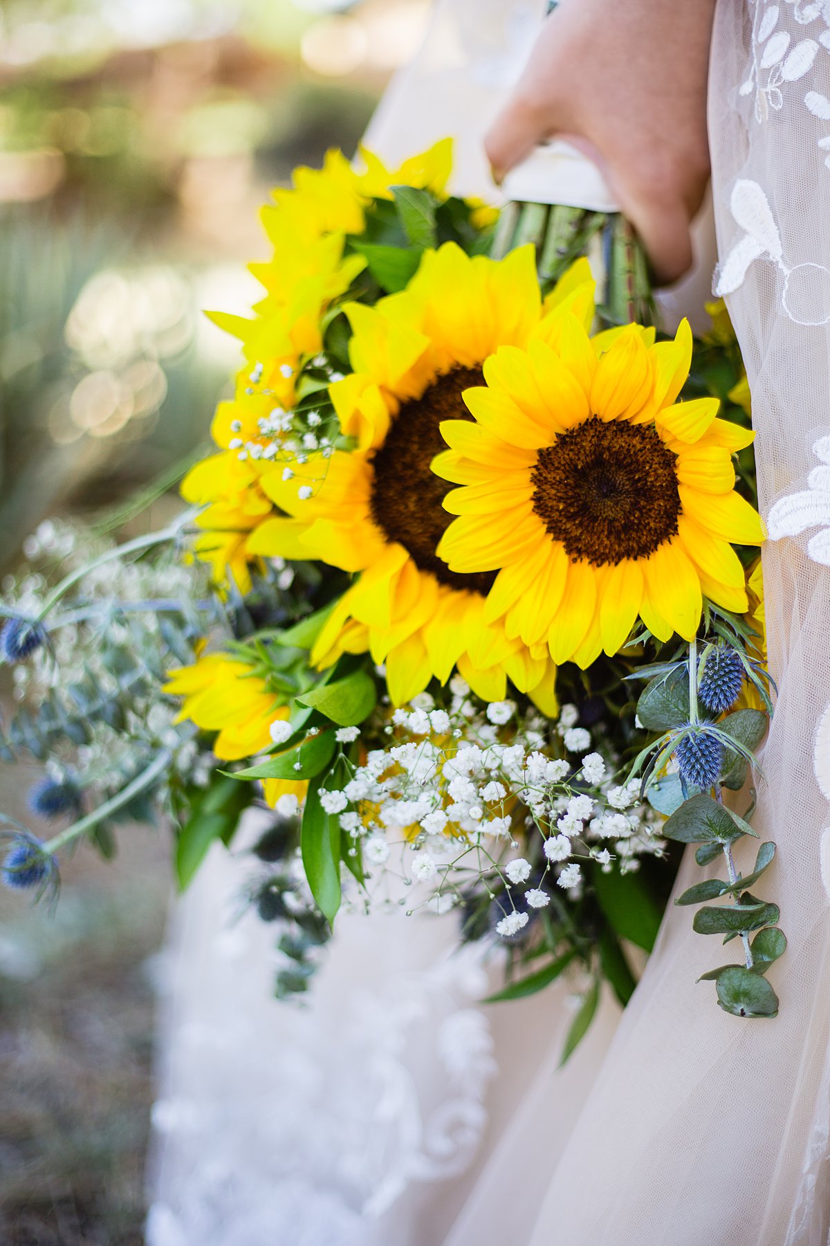 DIY sunflower, eucalyptus, baby's breath, and thistle bridal bouquet for a navy and yellow wedding.