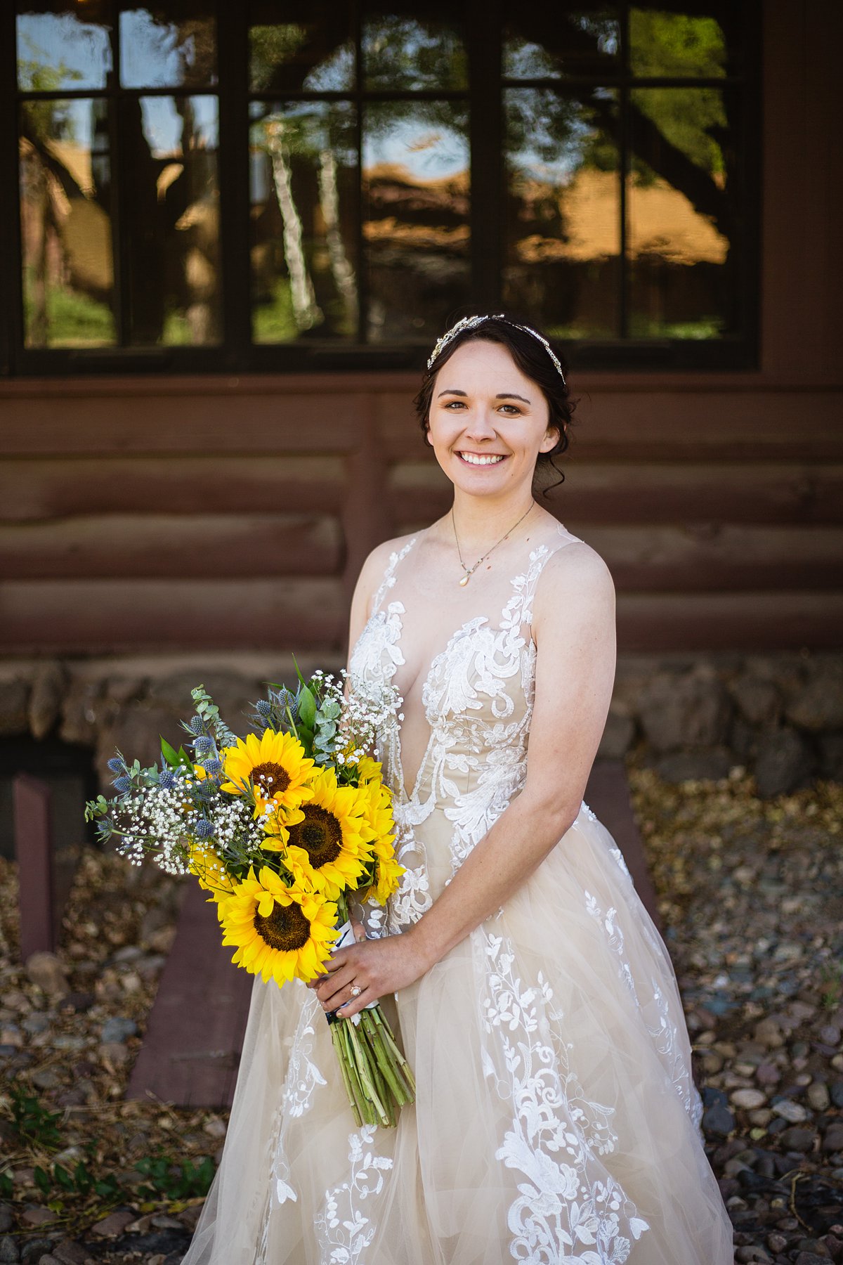Bride in nude and lace wedding dress holding sunflower bouquet by PMA Photography.