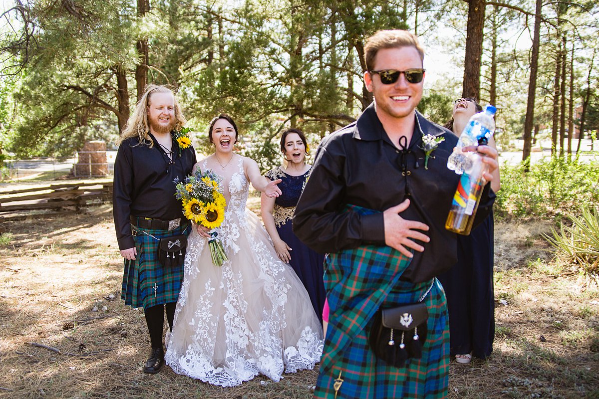 Groomsmen shows the bride and bridal party the hot pink boxers under his kilt by PMA Photography.