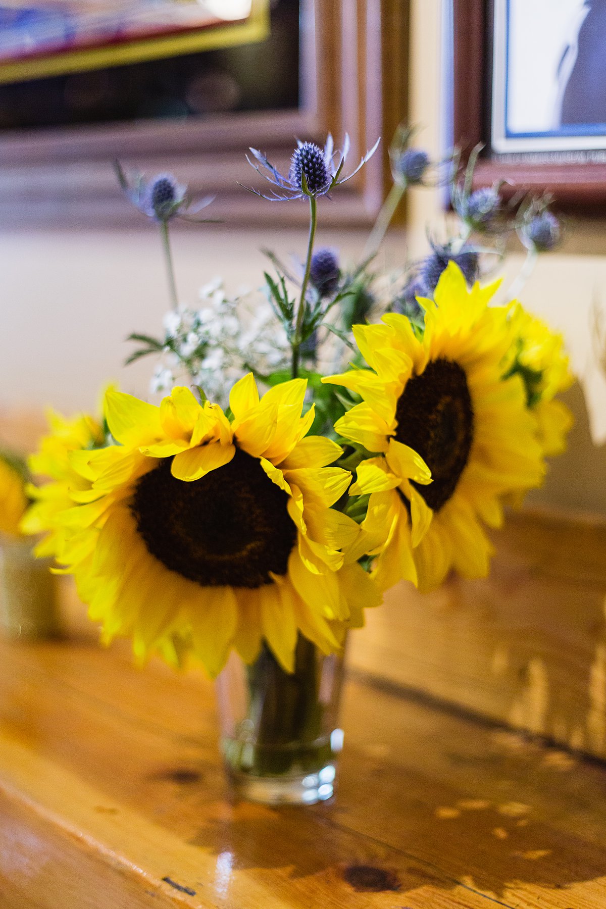 Sunflower, thistle, and baby's breath DIY centerpieces for a navy and yellow wedding by wedding photographers PMA Photography.