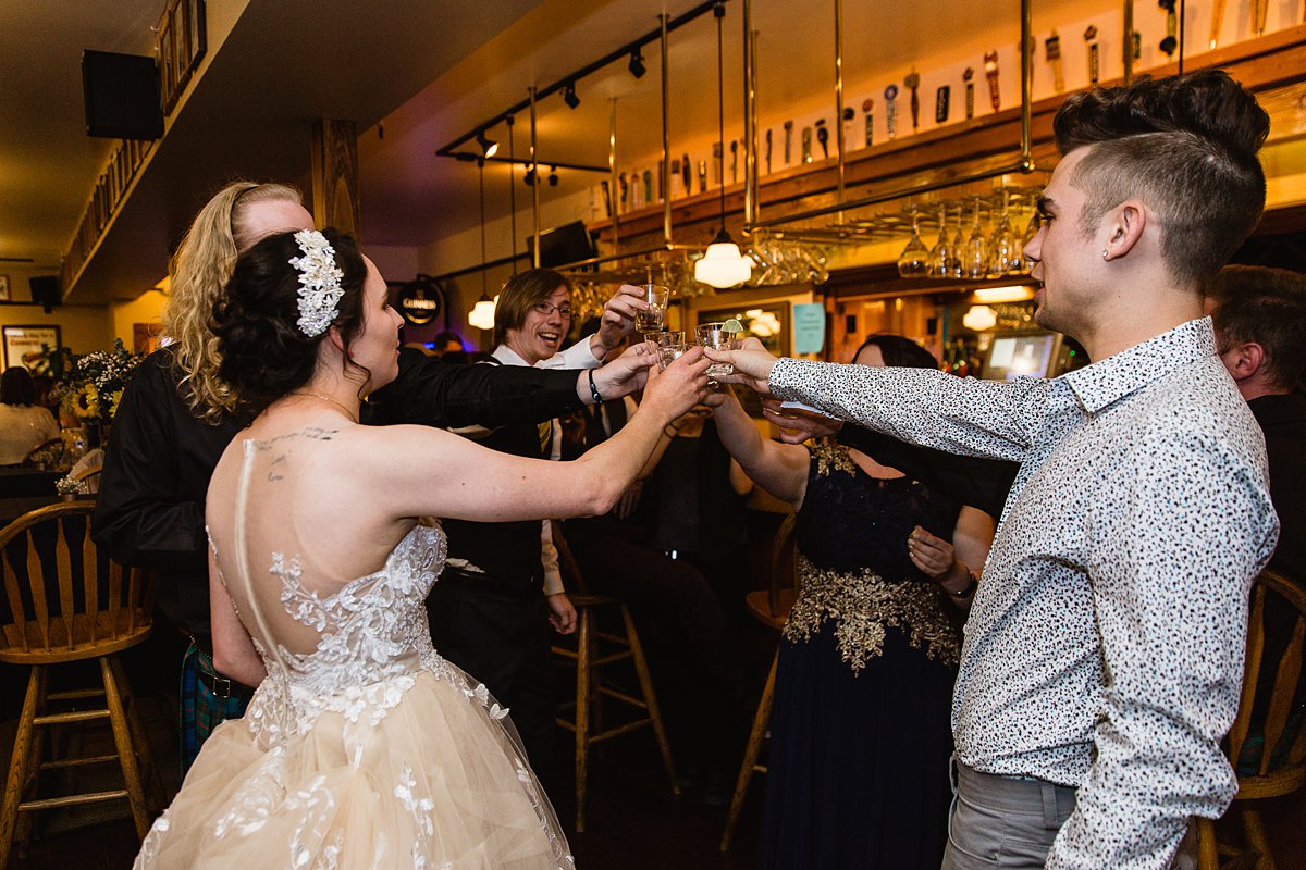 Bride and groom share shots with their guests at their wedding reception.