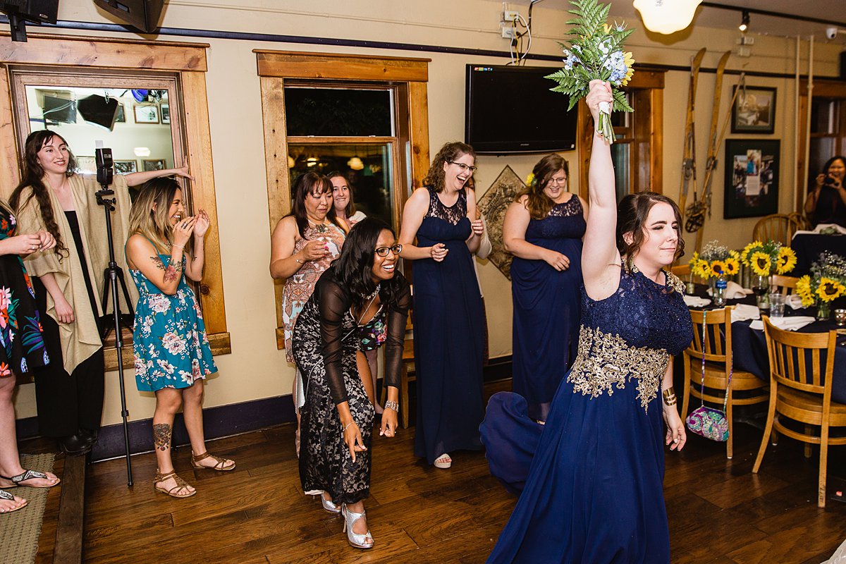 All the single ladies participate in the bouquet toss at a wedding reception at the Weatherford Hotel in Flagstaff Arizona by wedding photographers PMA Photography.