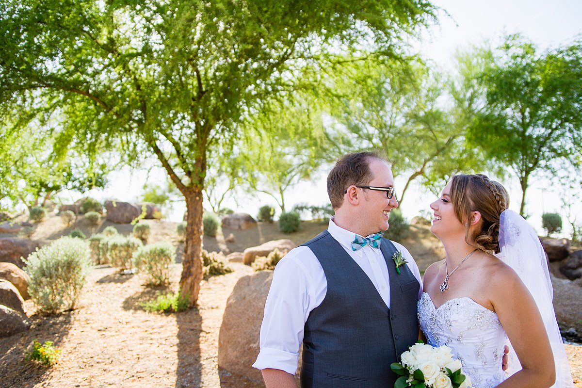 Bride and groom looking at each other at their turquoise and grey wedding by PMA Photography.