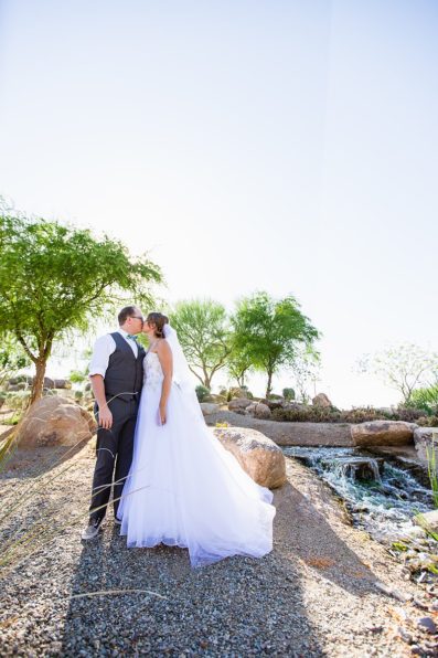 Bride and groom in front of a desert-scaped creek by Arizona wedding photographer PMA Photography.