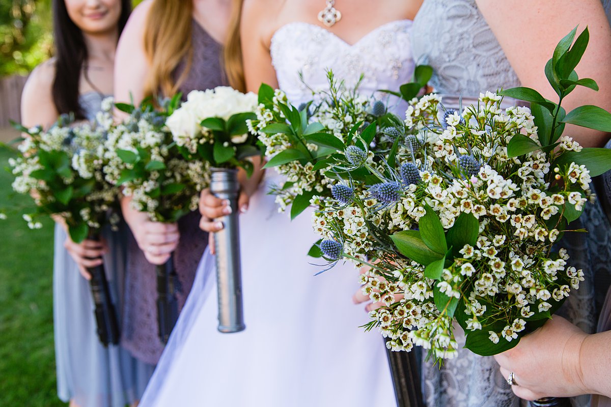 Simple was flower and thistle bridal bouquets in Star Wars light saber hilts by PMA Photography.