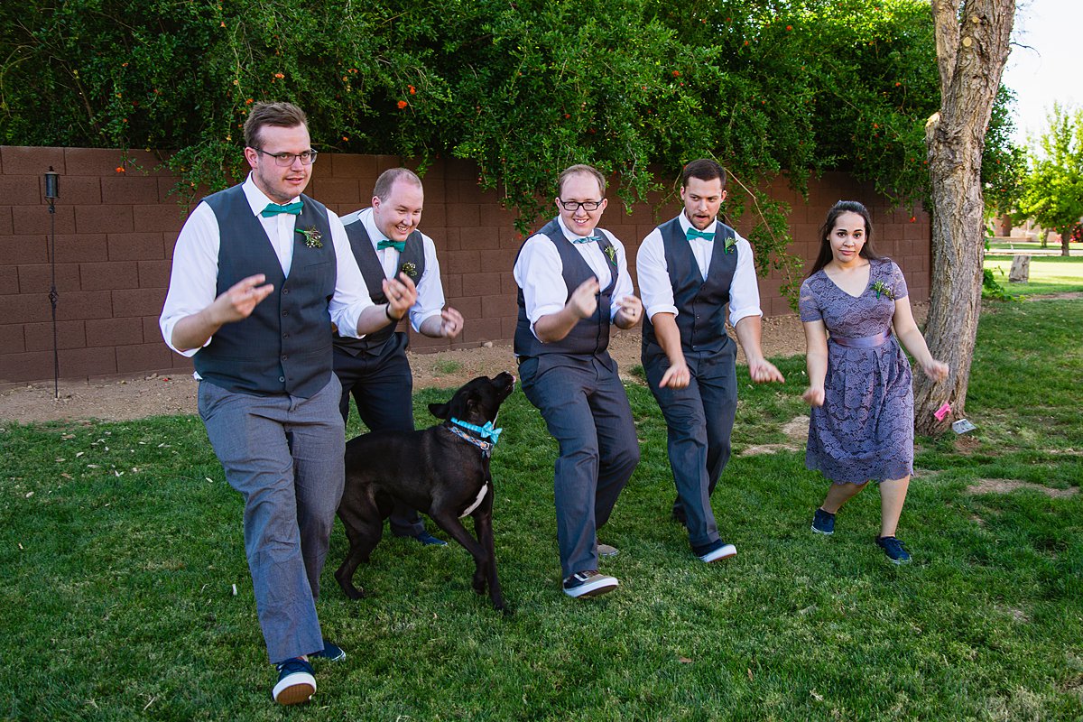 Groom with groomsmen and grooms-lady in grey and turquoise outfits for a DIY backyard wedding by Arizona wedding photographers PMA Photography.