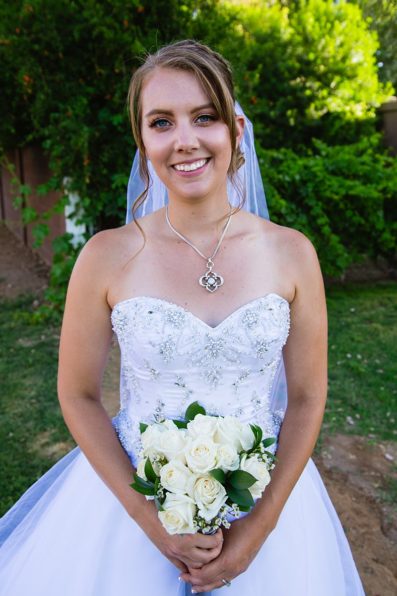 Bride with simple white rose bouquet on her wedding day by PMA Photography.