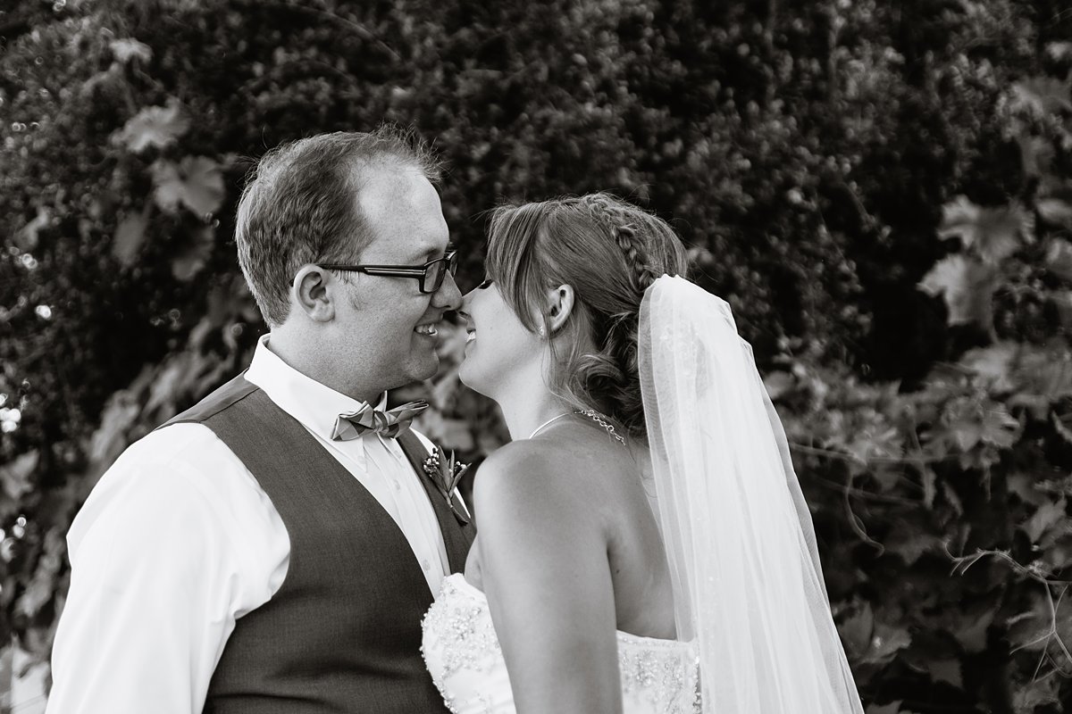 Black and white image of bride and groom sharing an intimate moment on their wedding day.