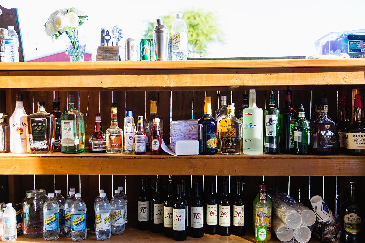 Images of the bottles behind the bar for mixed drinks at a DIY Back Yard wedding by PMA Photography.