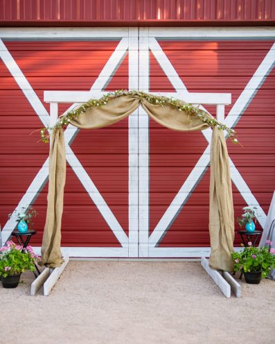 Backyard wedding ceremony simple alter in front of red barn by Arizona wedding photographers PMA Photography.