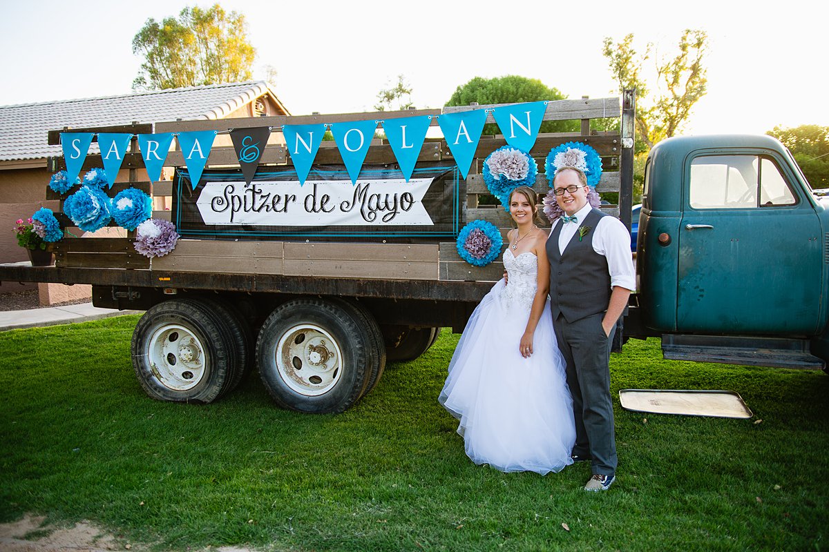 Bride and groom in front of the vintage truck decorated for their wedding day.