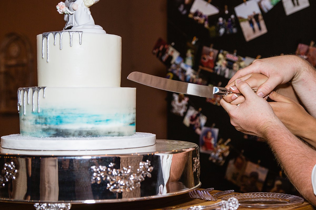 Bride and groom cutting their simple blue and grey cake by PMA Photography.