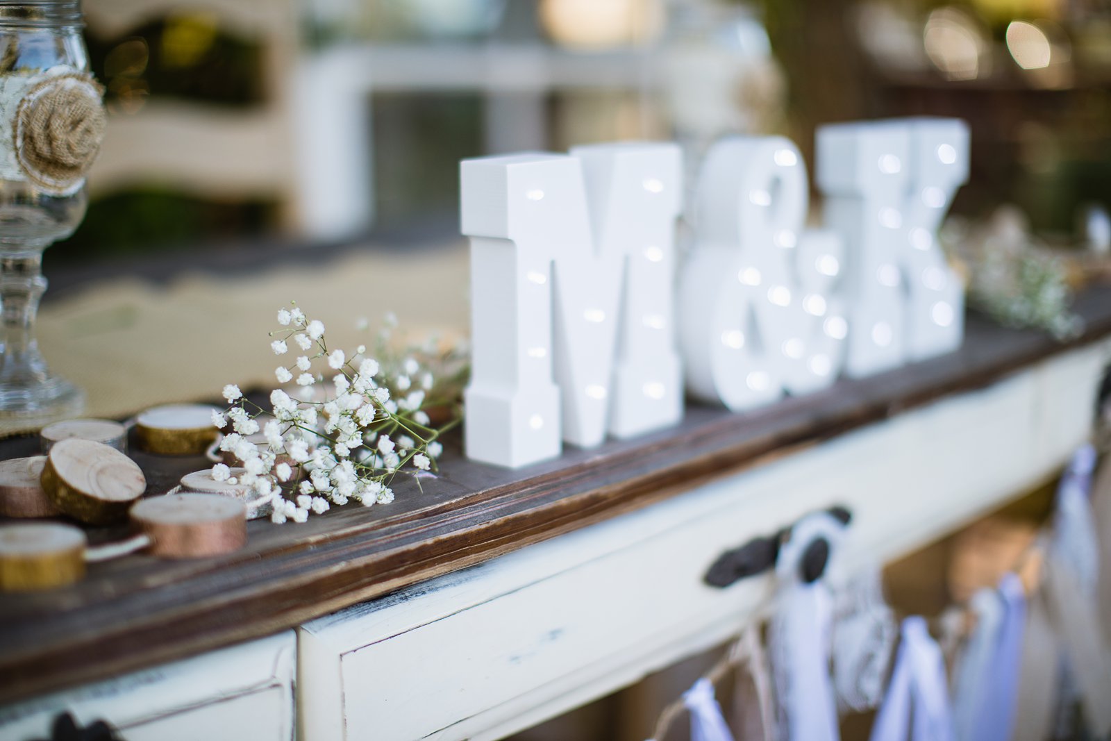 Image of rustic chic sweetheart table decorated with baby's breath and the couple's initials.