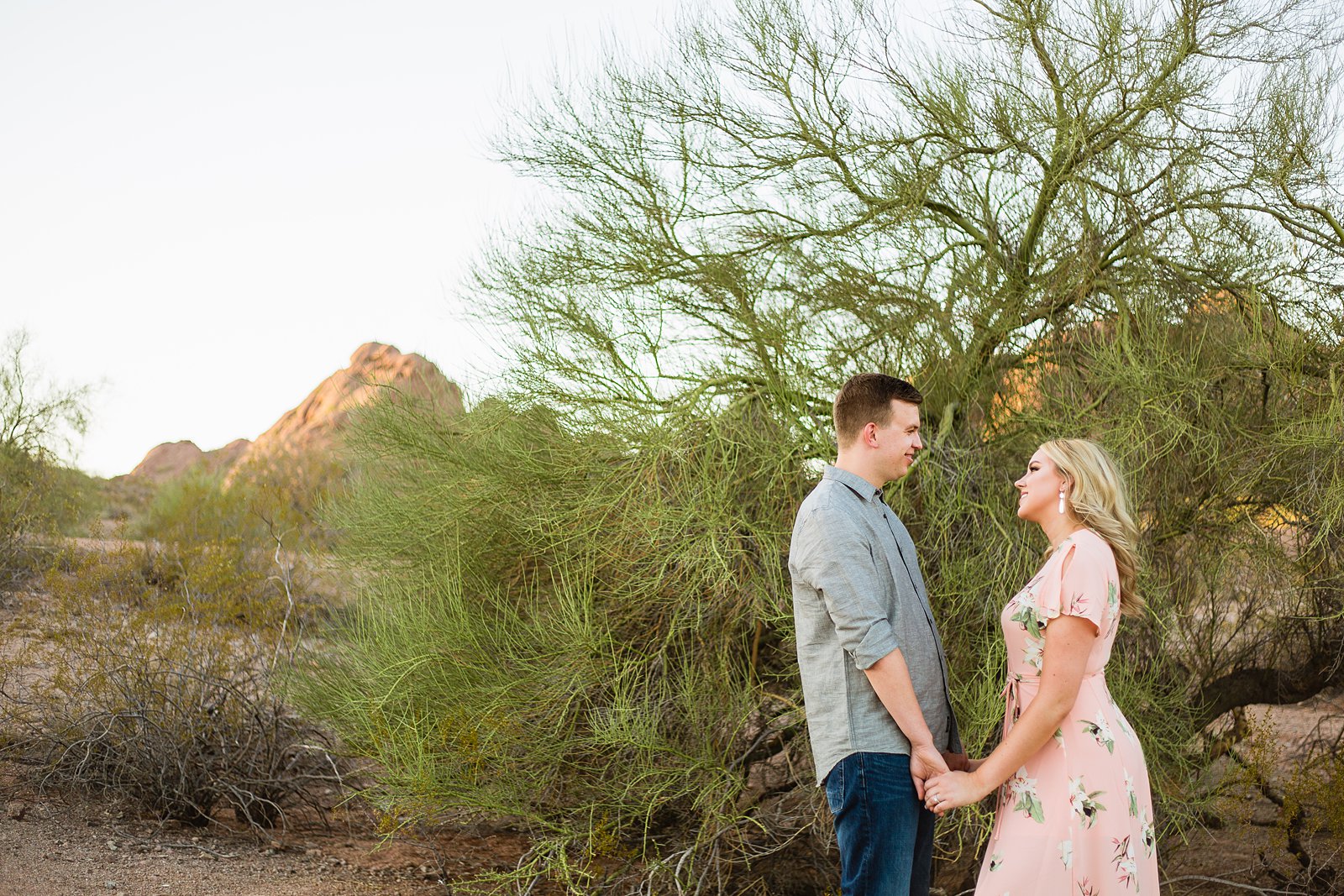 Couple looking at each other during their Papago Park engagement session by PMA Photography.