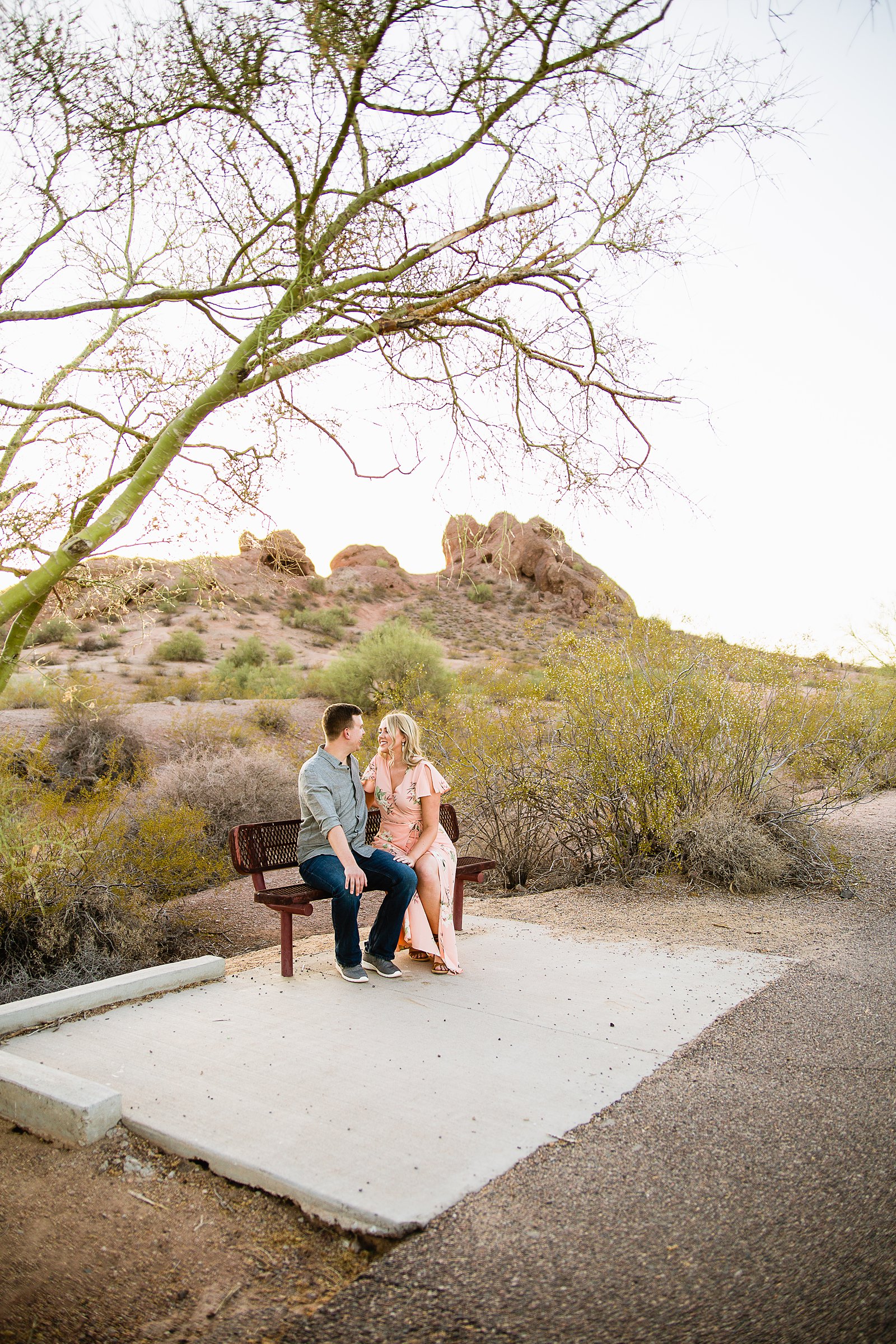 Couple sitting together on a bench during their engagement session by PMA Photography.