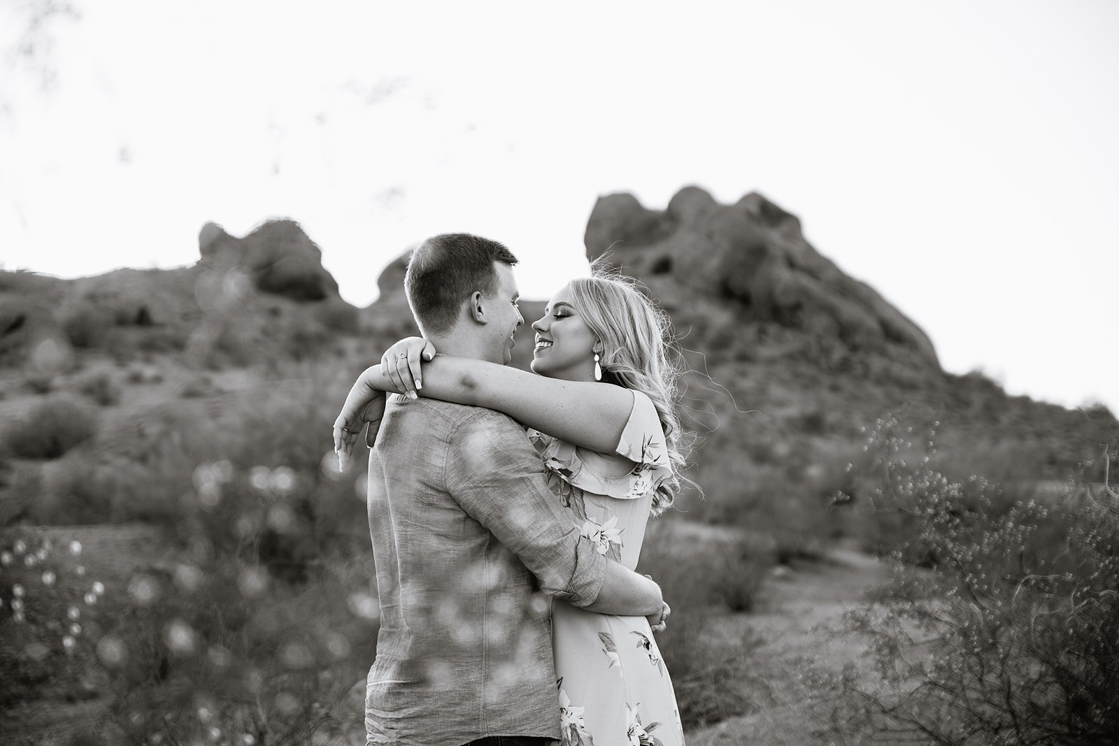 Black and white image of couple sharing an intimate moment during their desert engagement session by Arizona engagement photographer PMA Photography.