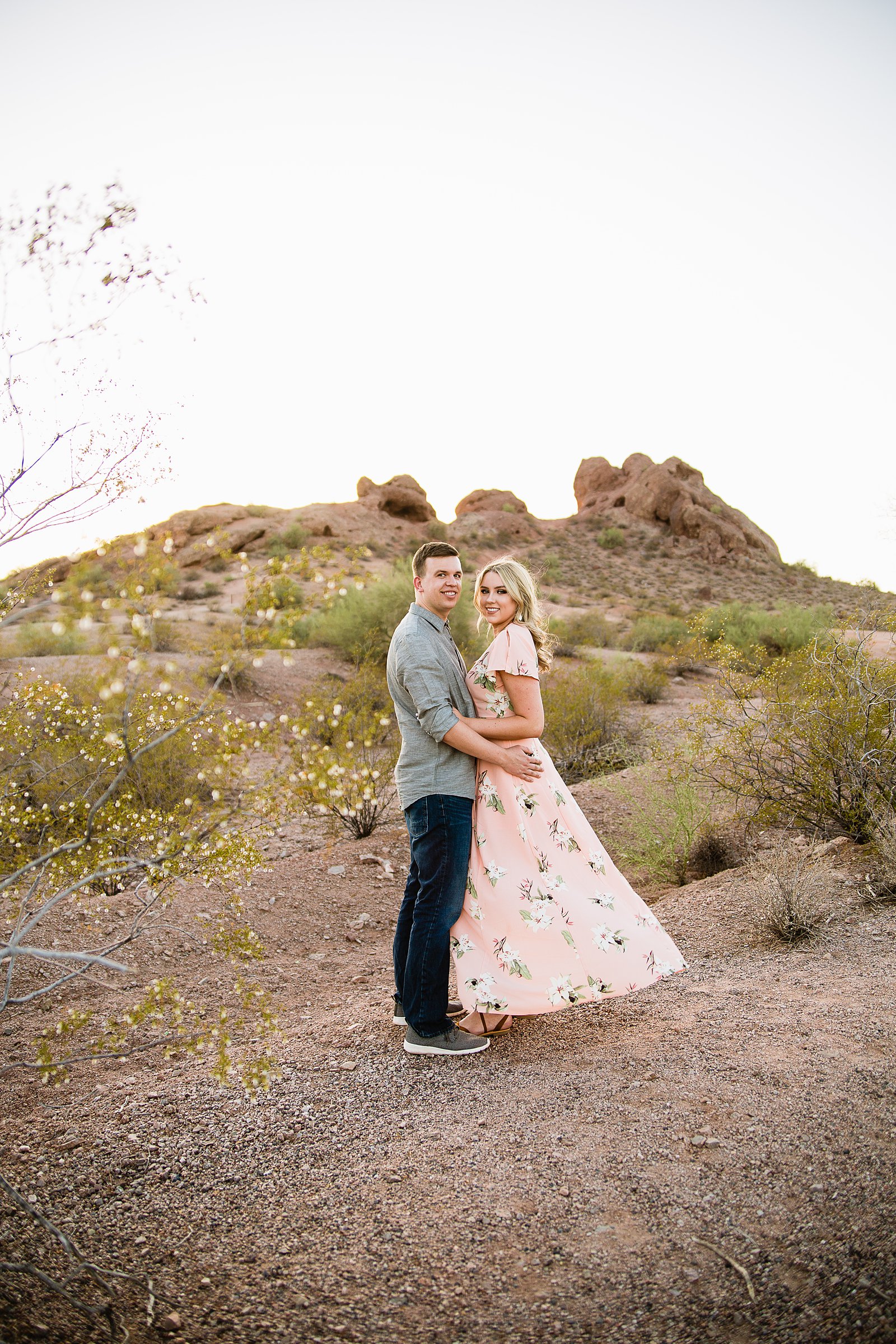 Couple posing during their desert engagement session at Papago Park by Phoenix engagement photographer PMA Photography.