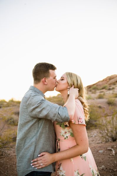 Couple share a kiss during their desert engagement session at Papago Park by Arizona engagement photographer PMA Photography.