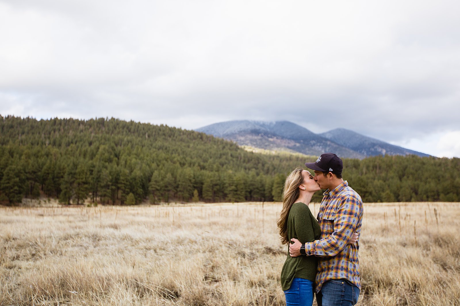 Couple share a kiss during their Flagstaff engagement session by PMA Photography.
