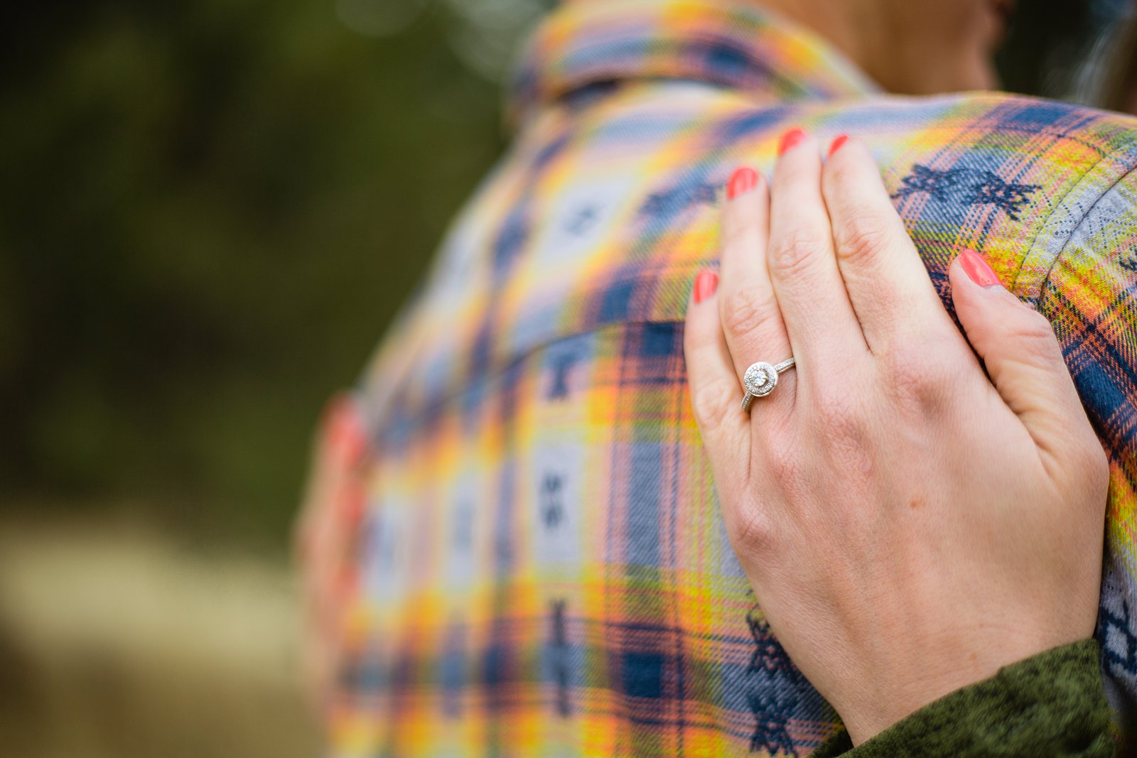 Brides simple round engagement ring while holding her groom during their engagement session by PMA Photography.