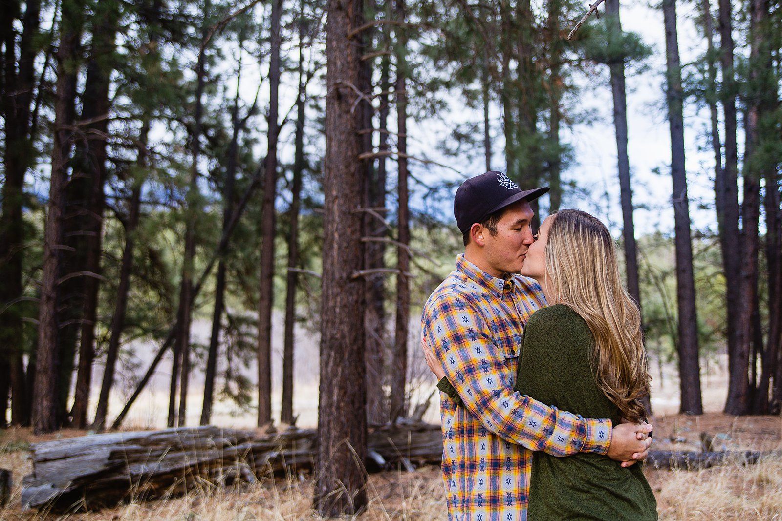 Couple share a kiss during their Flagstaff engagement session by PMA Photography.
