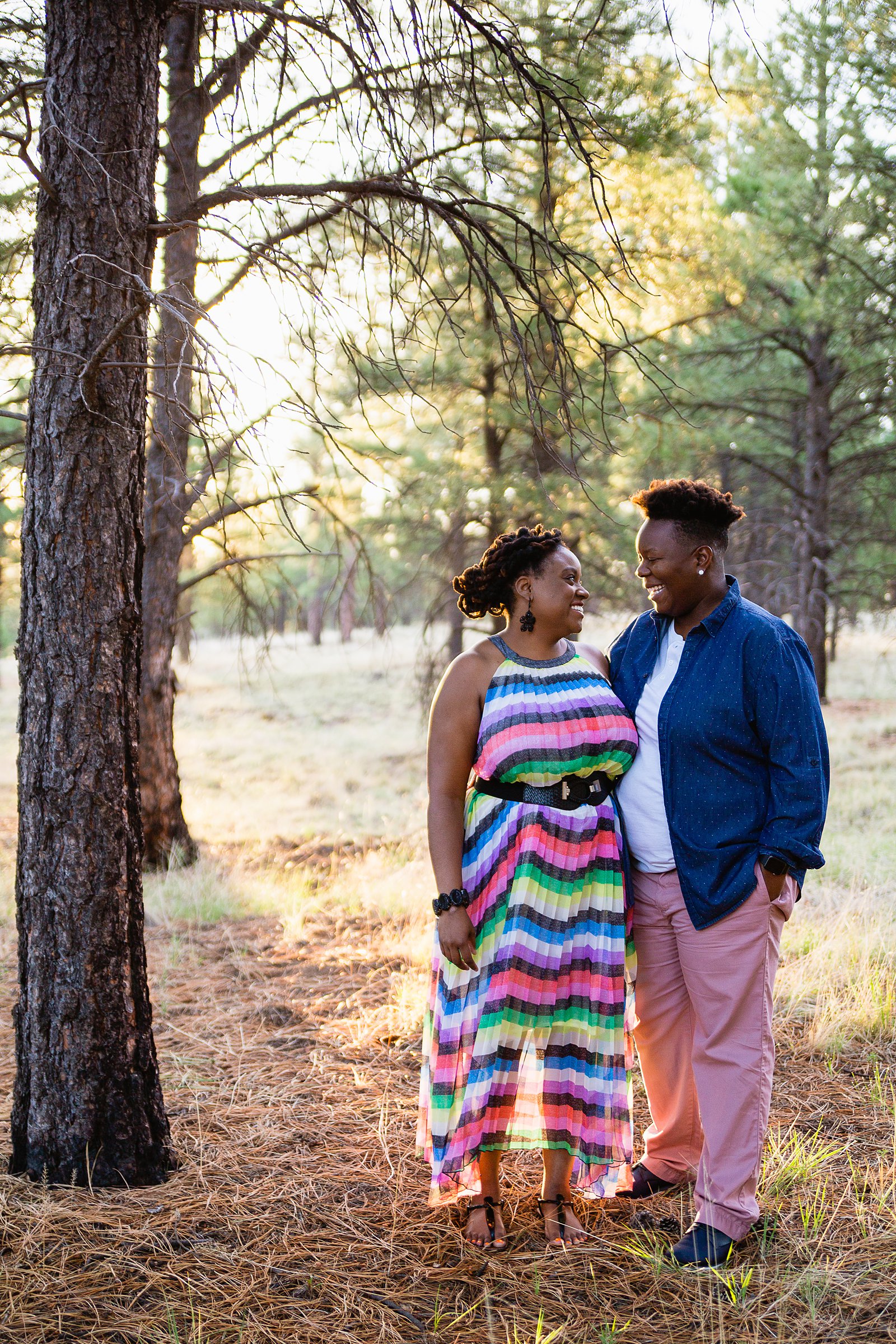 Same sex couple pose together during their Flagstaff engagement session in the woods by Flagstaff wedding photographer PMA Photography.