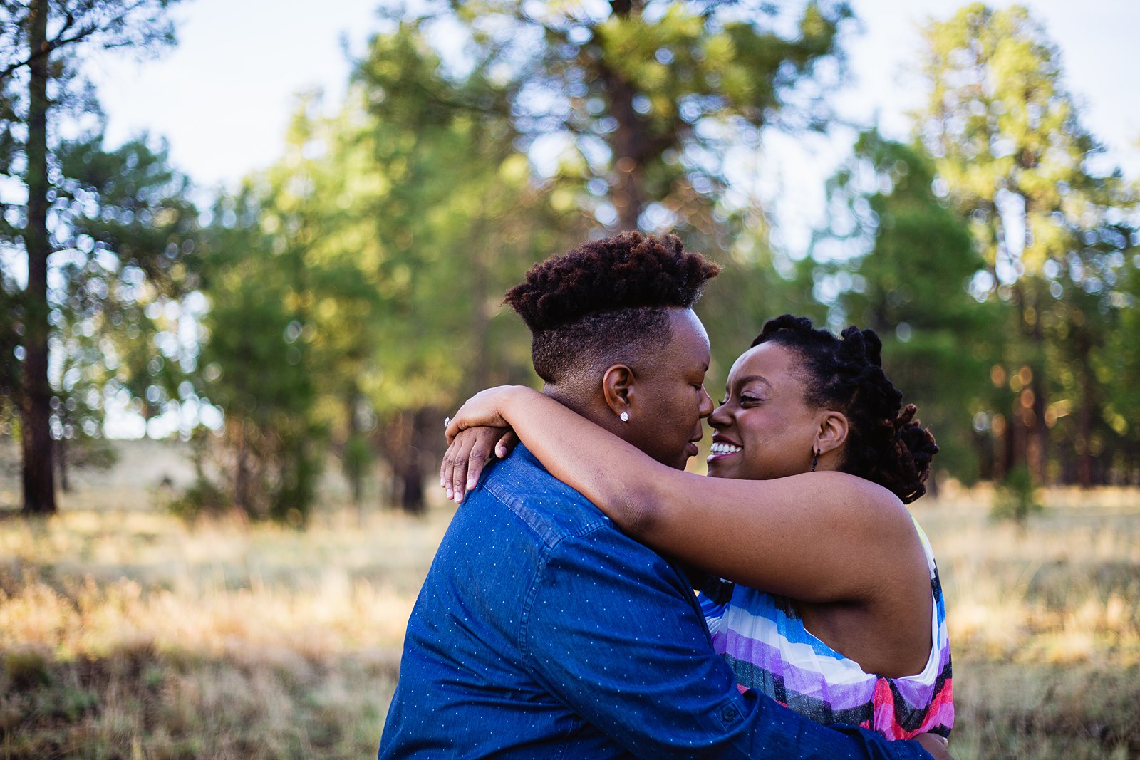 LGBT couple share an intimate moment during their sunrise engagement session by Flagstaff wedding photographer PMA Photography.