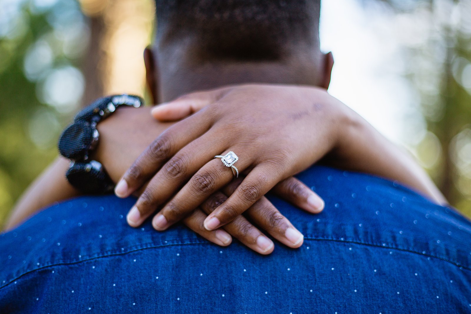 Close up of simple engagement ring during engagement session by PMA Photography.