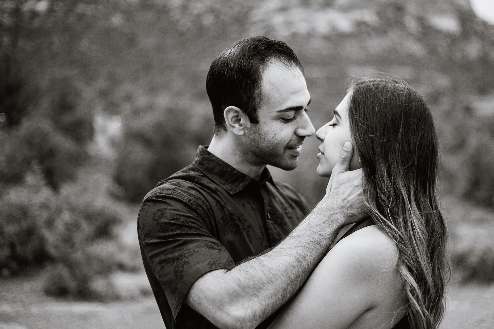 Couple share an intimate moment at their Sedona engagement session by Arizona engagement photographer PMA Photography.